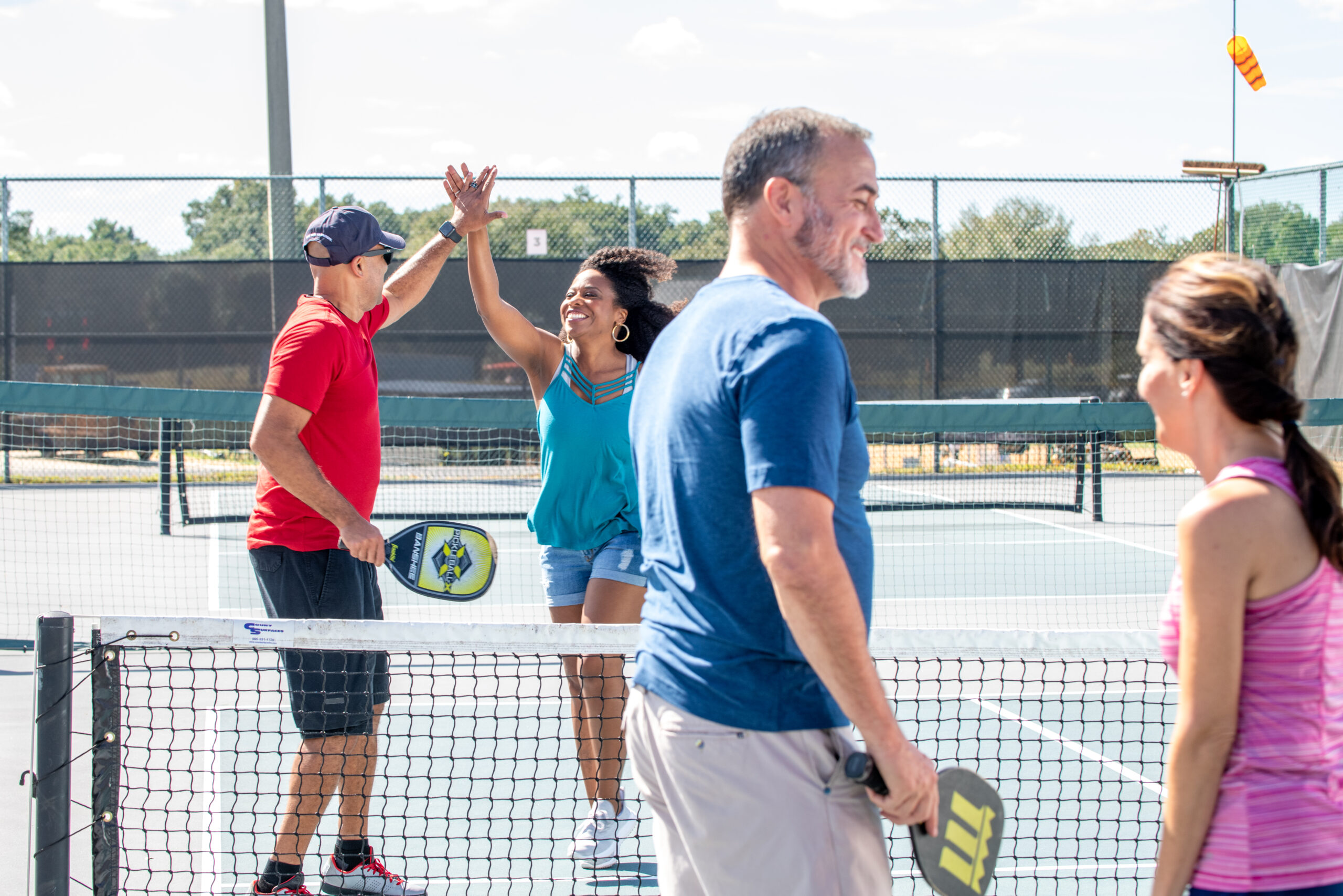 Two people celebrating a win playing pickleball