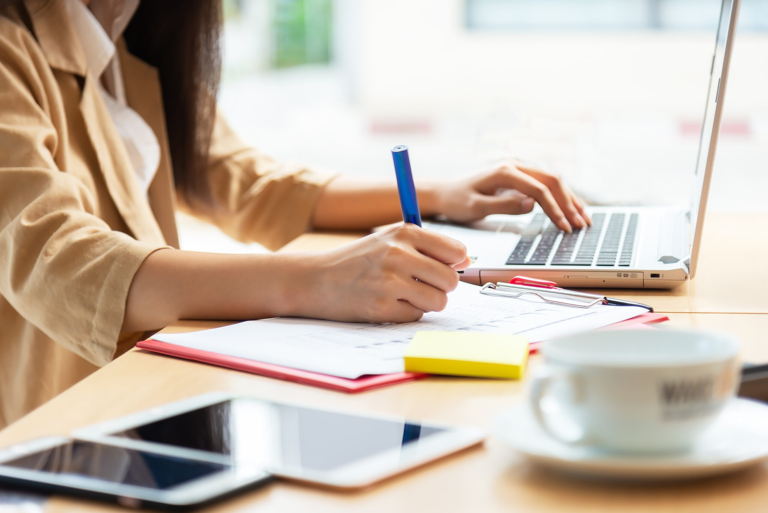 Asian woman using laptop at home while sitting the wooden
