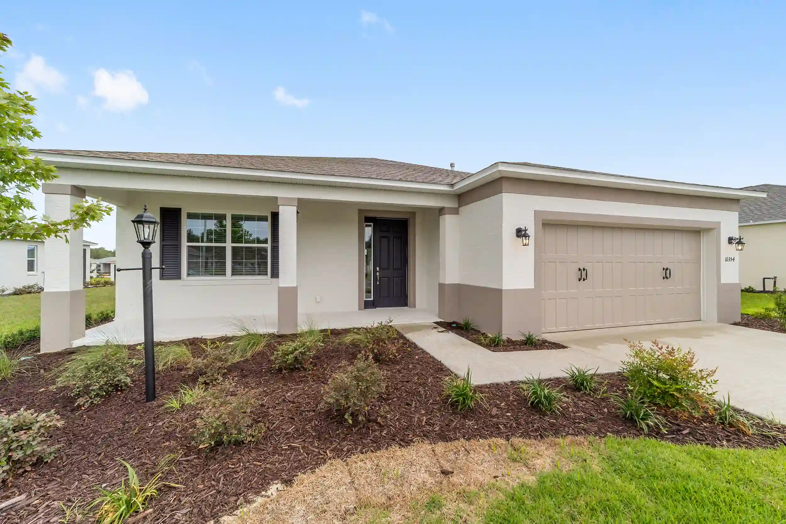 MIR_10354-SW-105th-Terrace-Ocala_Lot128_exterior facade new construction open floor plan home for sale in Ocala FL in amazing community to retire, one story house with 2 car garage and great landscaping